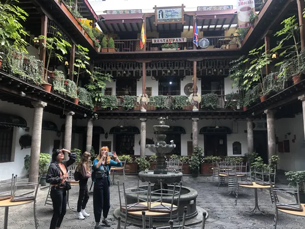 Tres chicas turistas explorando el Palacio Arzobispal en Quito