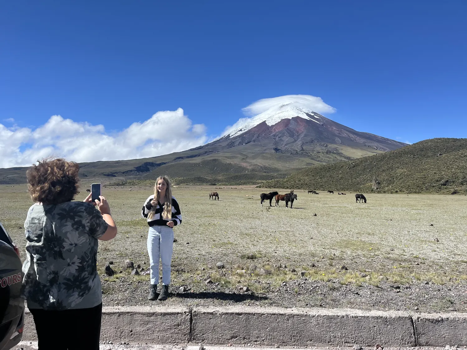 Madre e hija disfrutando del paisaje en Cotopaxi con caballos salvajes