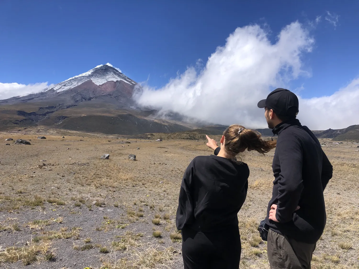 Pareja señalando la cima del Cotopaxi desde Limpiopungo